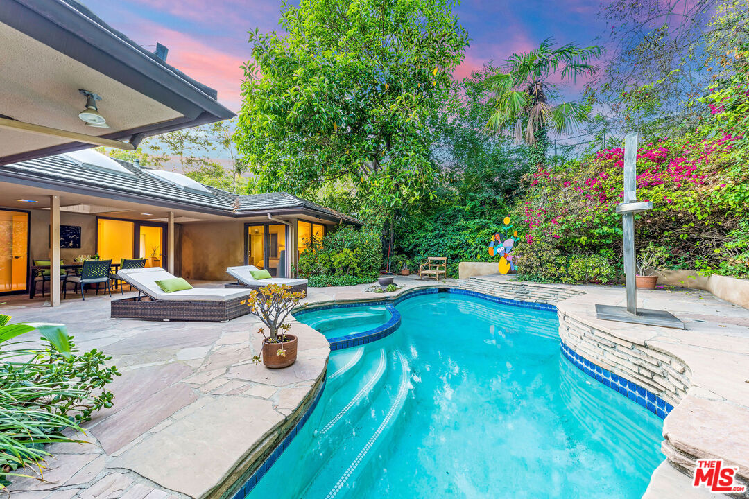 10871 Chalon Road Los Angeles, CA 90077 - Photo 3 of 41 a view of a patio with table and chairs potted plants and large tree