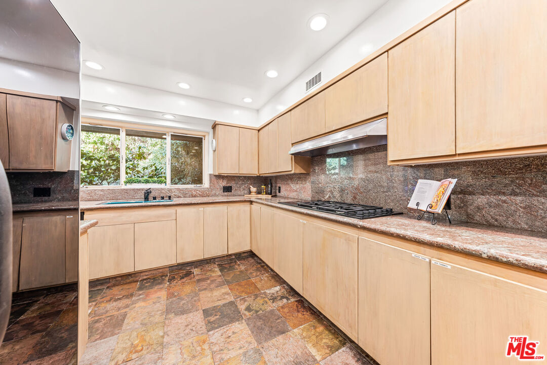 10871 Chalon Road Los Angeles, CA 90077 - Photo 21 of 41 a kitchen with granite countertop white cabinets and white appliances