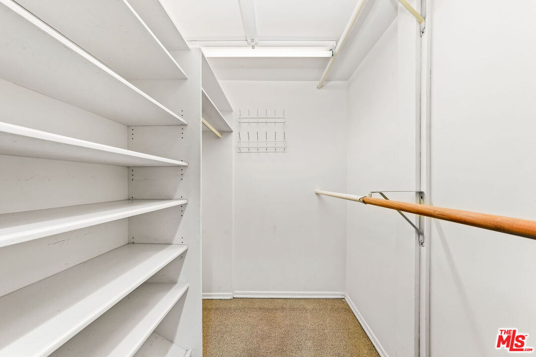 10871 Chalon Road Los Angeles, CA 90077 - Photo 37 of 41 a view of walk in closet with empty racks