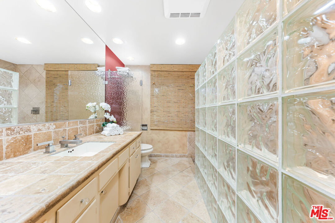 10871 Chalon Road Los Angeles, CA 90077 - Photo 39 of 41 a bathroom with a double vanity sink and a large mirror
