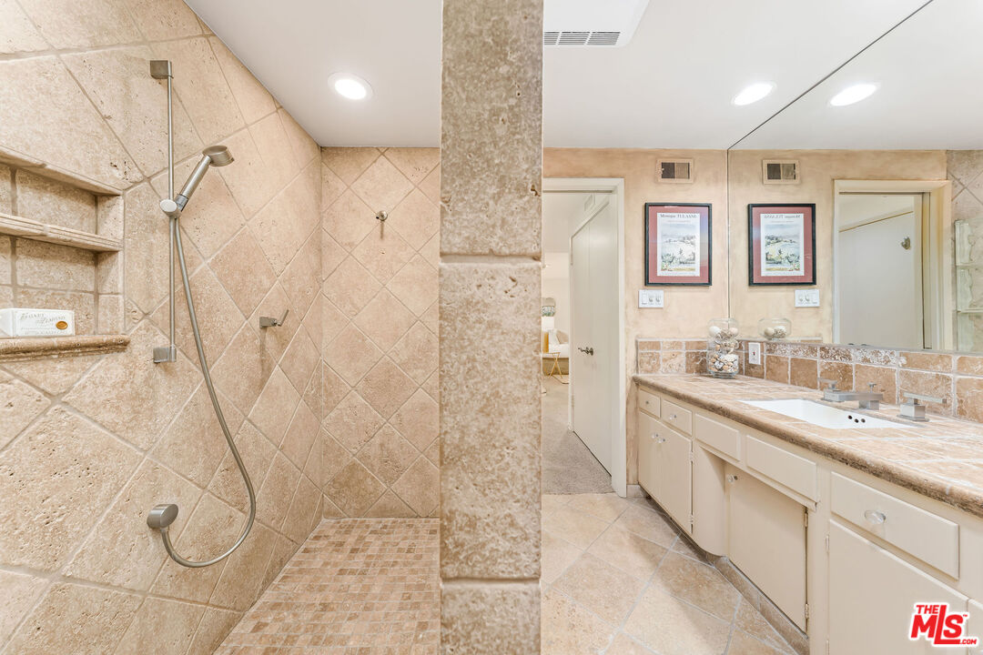 10871 Chalon Road Los Angeles, CA 90077 - Photo 40 of 41 a bathroom with a double vanity sink a mirror and shower