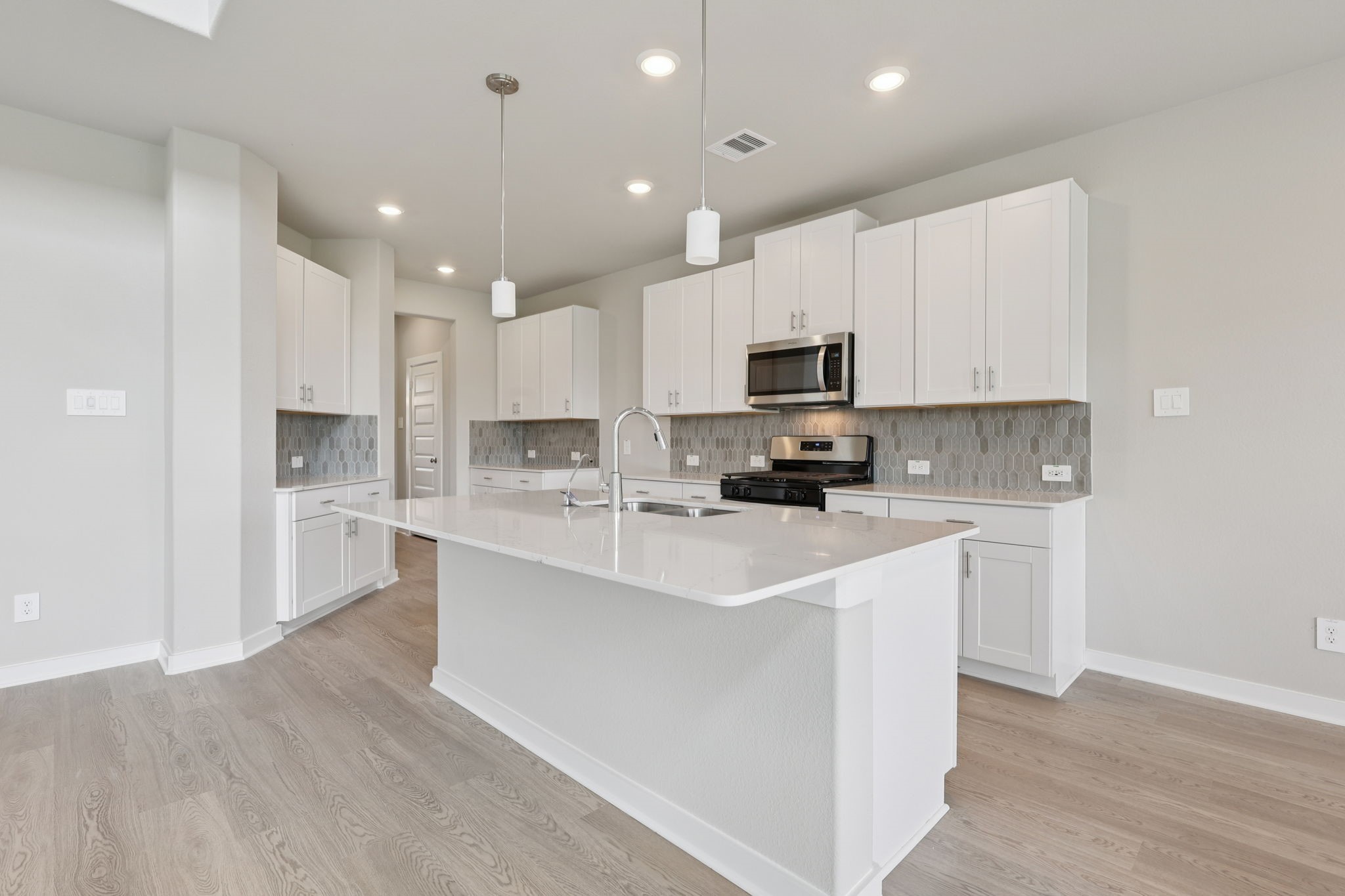 5710 Chamberlain Crossing Rosenberg, TX 77471 - Photo 13 of 40 a kitchen with kitchen island a white cabinets and wooden floor
