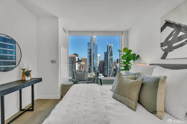 a bedroom with bed a mirror and a window