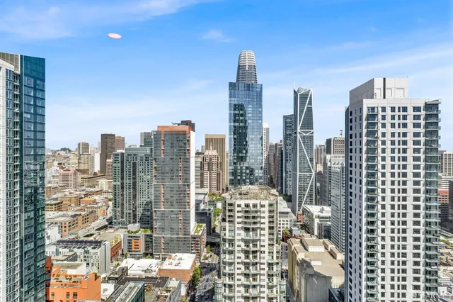 a view of a hallway with wooden floor and a bathroom