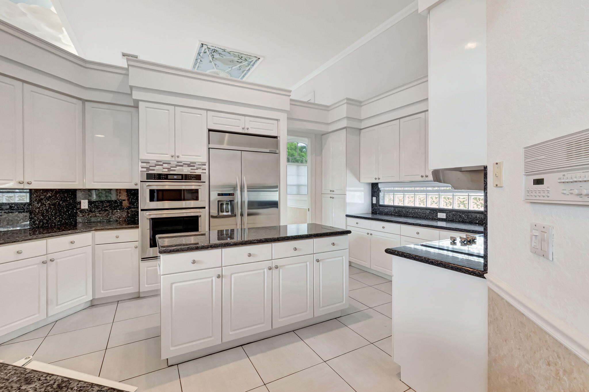 9152 Long Lake Palm Drive Boca Raton, FL 33496 - Photo 13 of 36 a kitchen with white cabinets and appliances