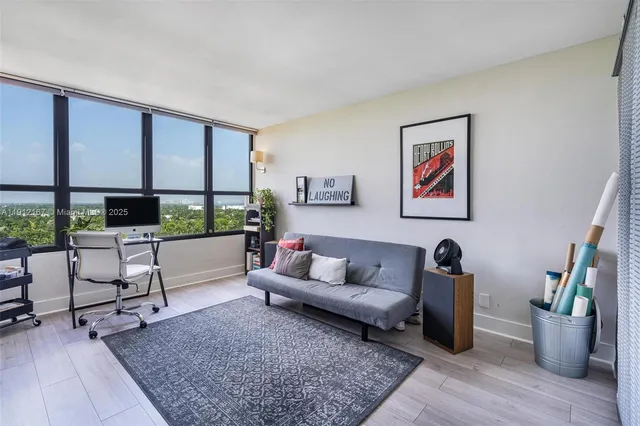 a living room with lots of books and a large window