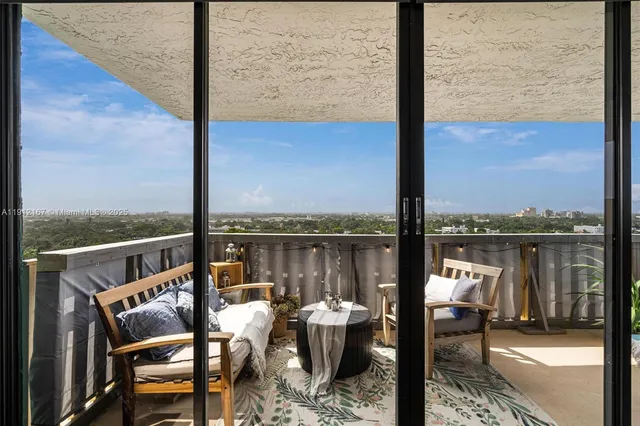 a view of a city from a balcony with outdoor seating