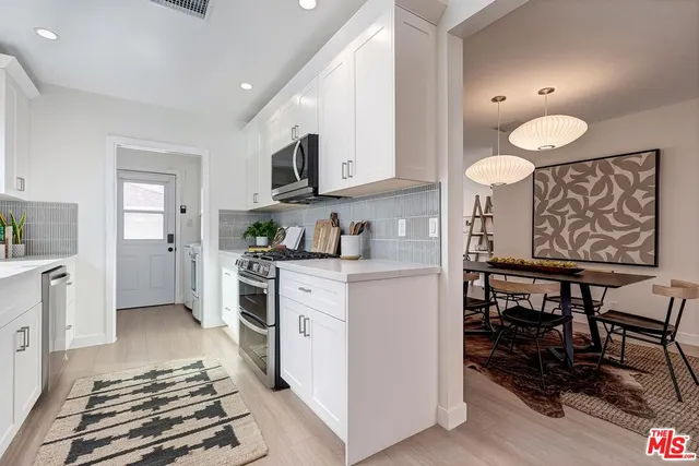 a kitchen with stainless steel appliances a stove a sink and a refrigerator
