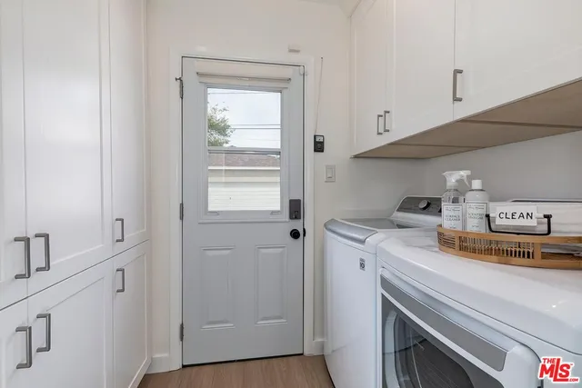 a utility room with cabinets washer and dryer