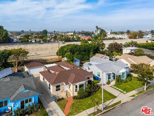 an aerial view of multiple houses with a lake