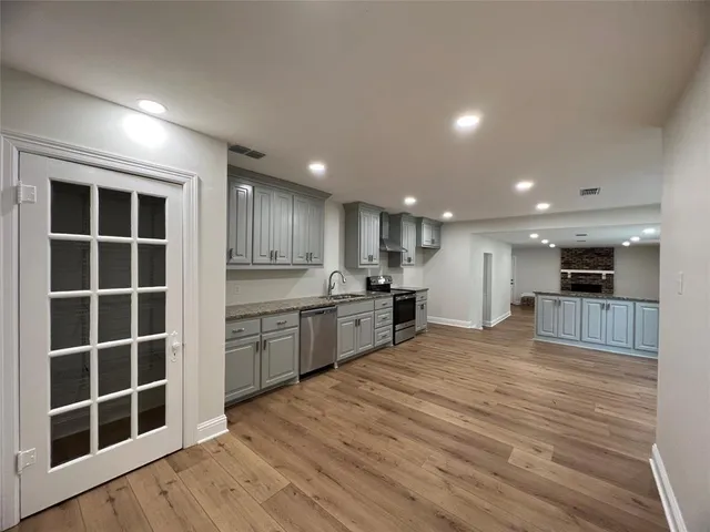 a large kitchen with kitchen island granite countertop a large counter top stainless steel appliances and cabinets