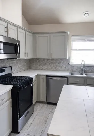 a kitchen with stainless steel appliances granite countertop a sink stove and cabinets