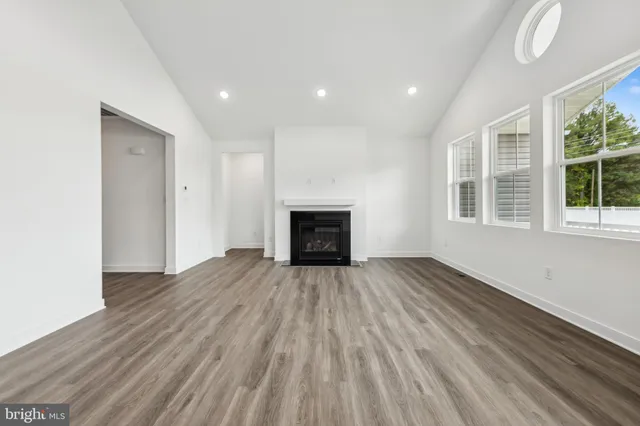 a view of empty room with wooden floor and fireplace