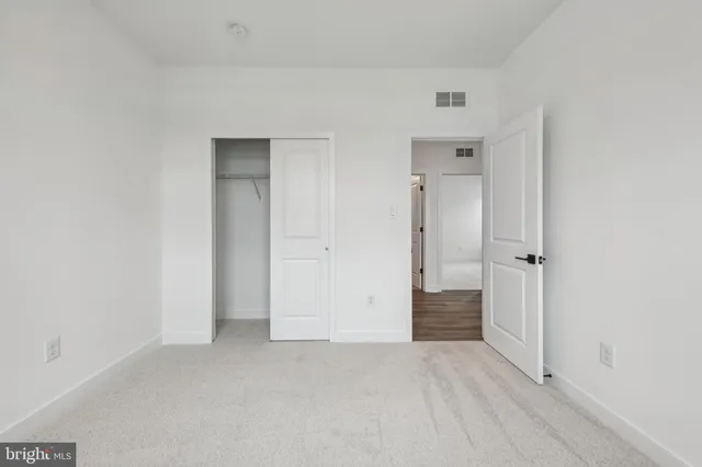 an empty room with closet and mirror