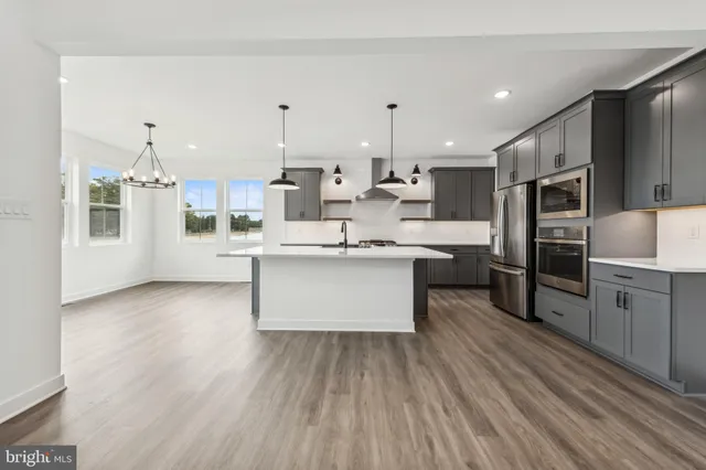 a large kitchen with a center island stainless steel appliances and cabinets