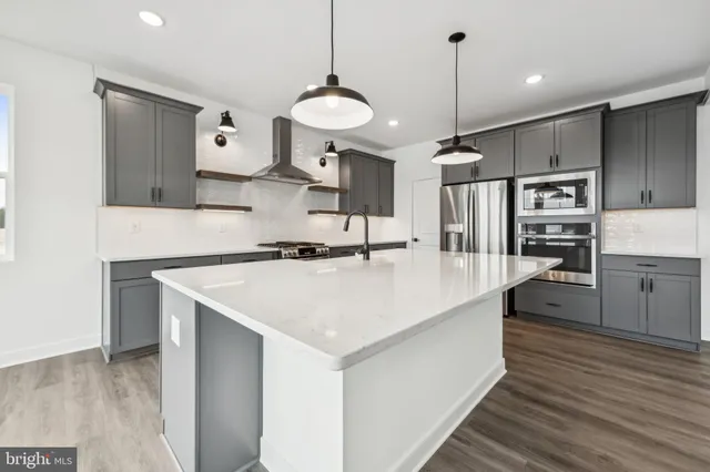 a kitchen with stainless steel appliances kitchen island a sink and a refrigerator
