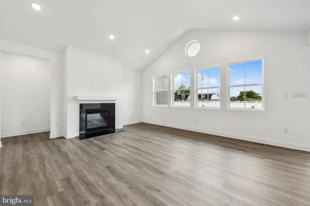 a view of empty room with wooden floor and fireplace