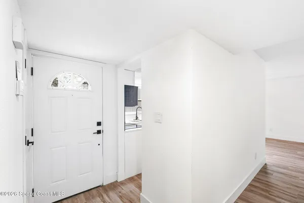 a view of a hallway with wooden floor