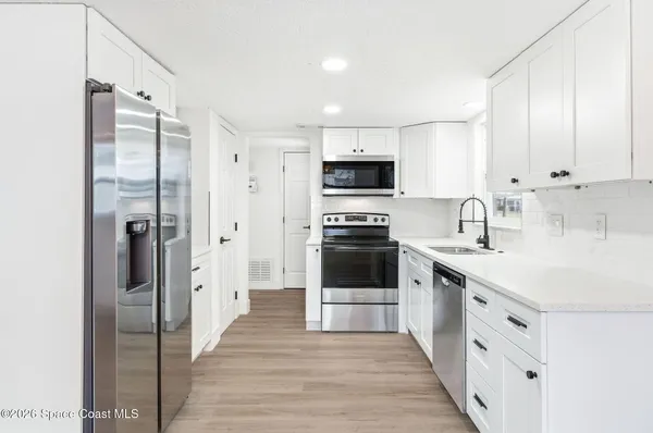 a kitchen with cabinets stainless steel appliances and a counter space