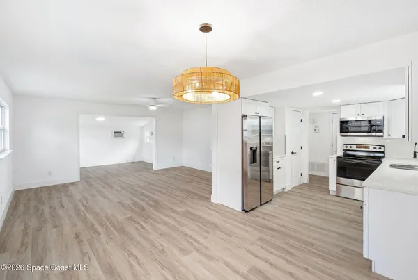 a view of a kitchen with wooden floor and a refrigerator