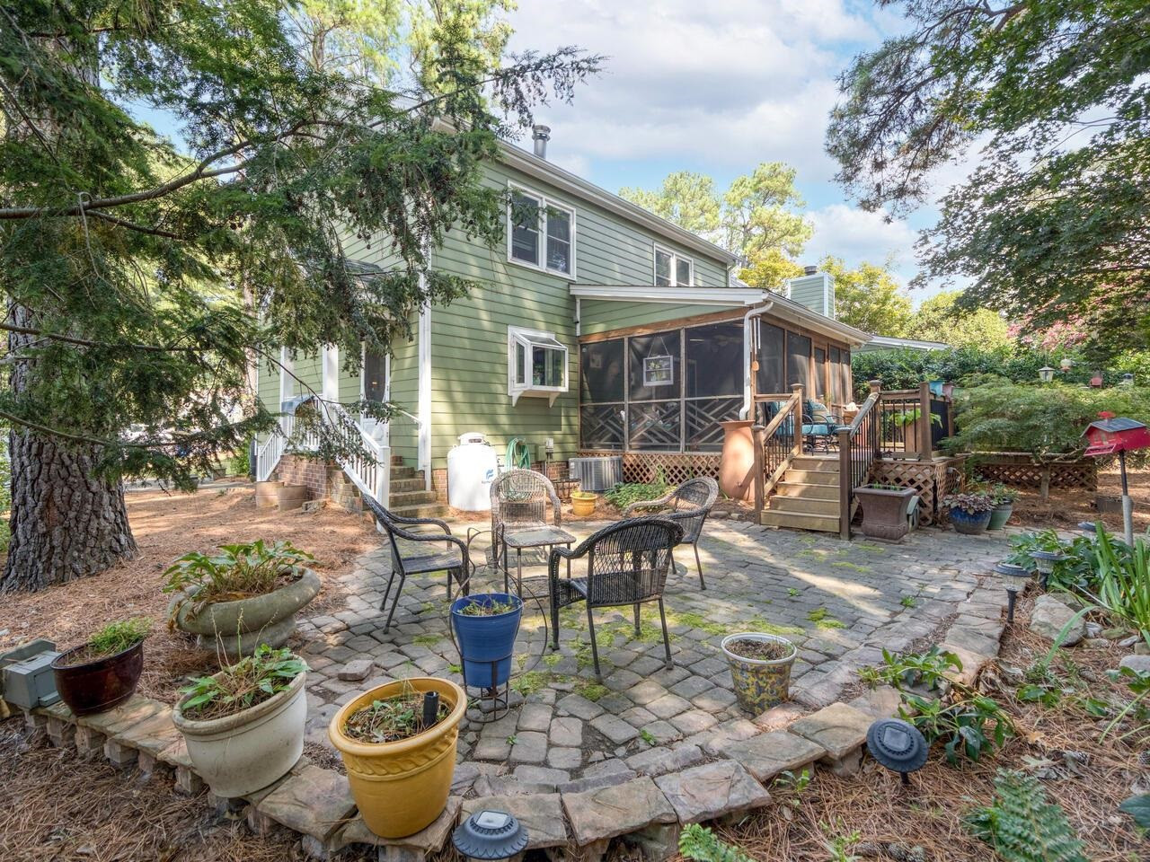 2603 Sawmill Road Raleigh, NC 27613 - Photo 52 of 53 a view of a patio with table and chairs potted plants and a large tree