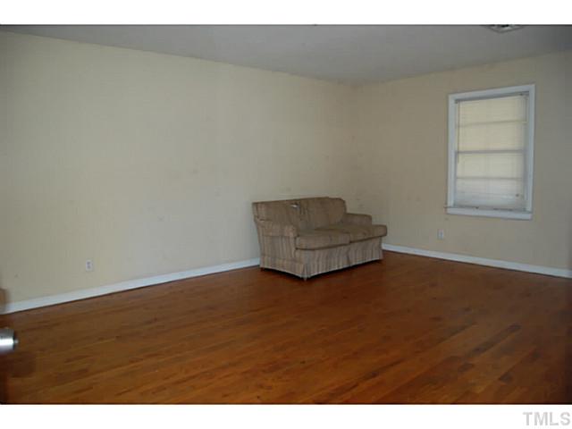 3204 Sanderford Road Raleigh, NC 27610 - Photo 3 of 15 a view of an empty room with wooden floor and a window