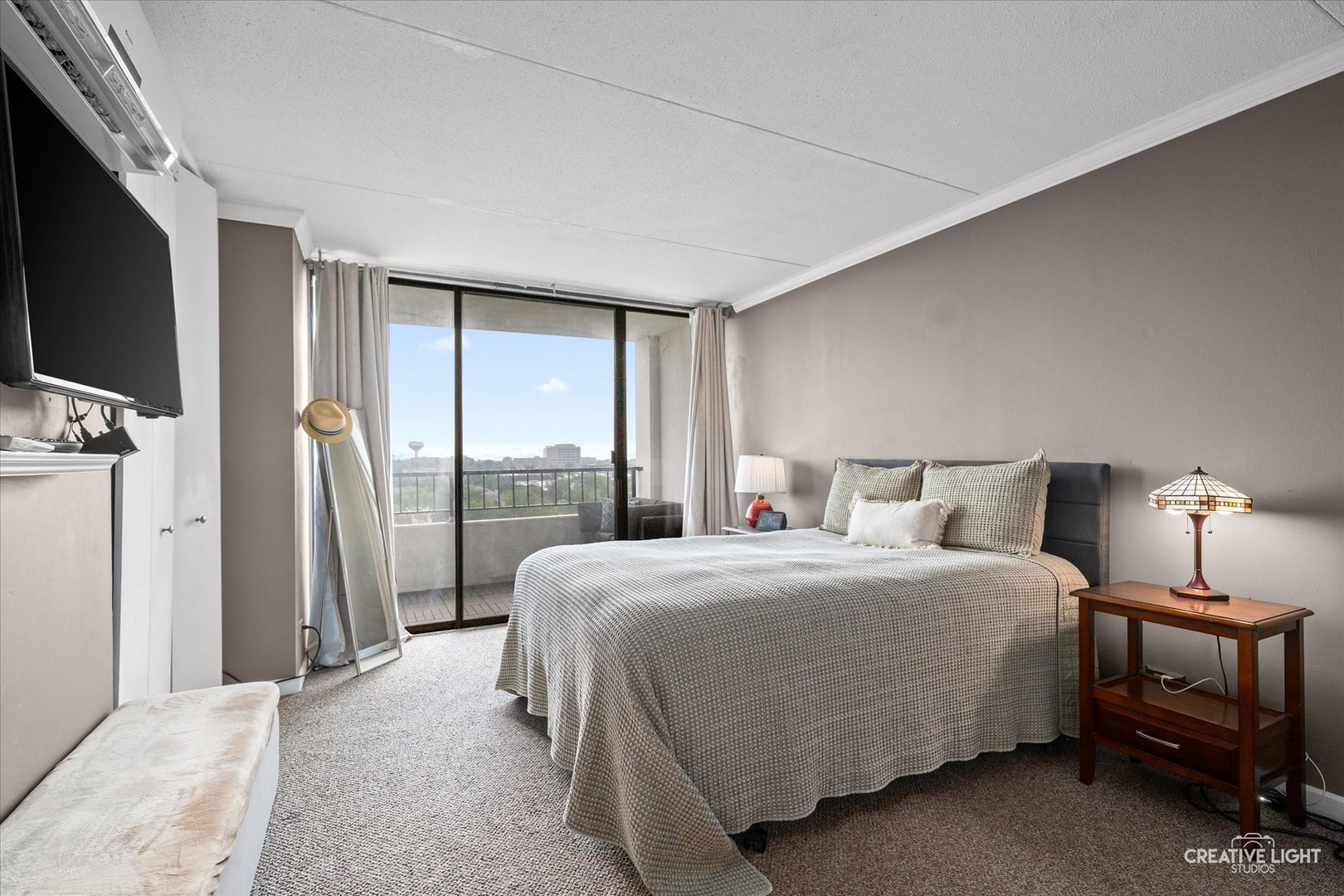 2005 South Finley Road, Unit 1209 Lombard, IL 60148 - Photo 10 of 29 a bedroom with a bed flat screen tv and a large window