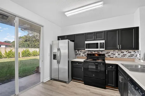 a kitchen with stainless steel appliances granite countertop a stove sink and refrigerator