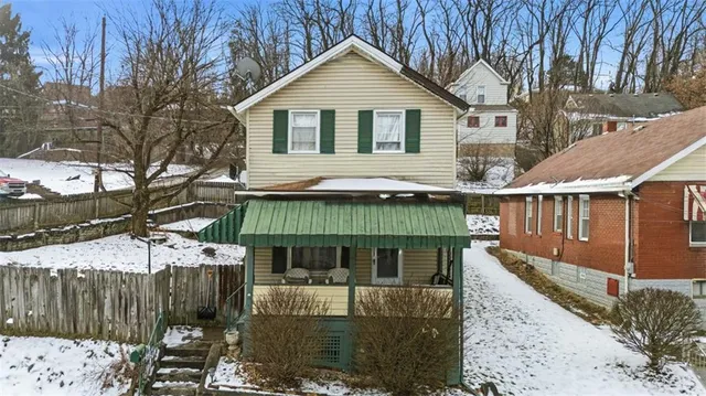 a front view of a house with a yard and wooden fence