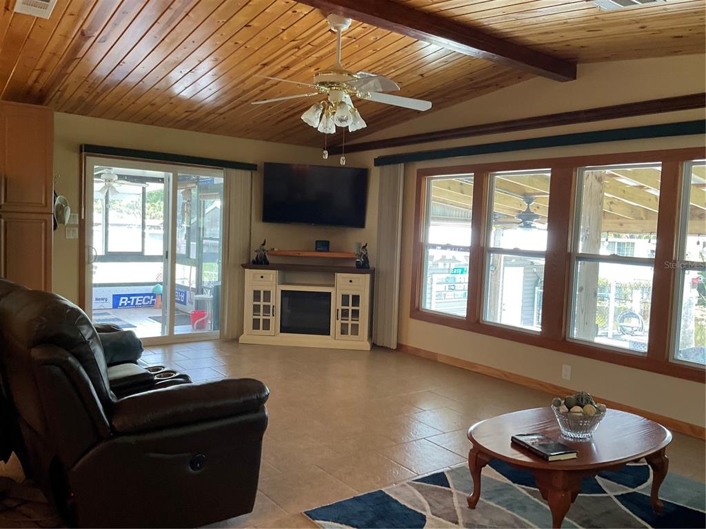 1558 Chobee Street Okeechobee, FL 34974 - Photo 19 of 63 a living room with furniture a fireplace and a chandelier