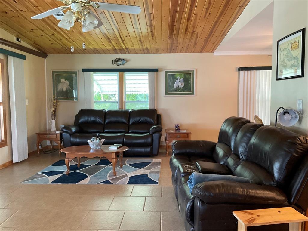 1558 Chobee Street Okeechobee, FL 34974 - Photo 20 of 63 a living room with furniture a couch and a chandelier