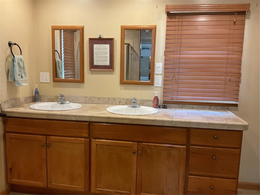 1558 Chobee Street Okeechobee, FL 34974 - Photo 27 of 63 a bathroom with a granite countertop sink and a mirror
