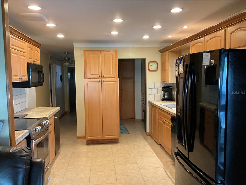 1558 Chobee Street Okeechobee, FL 34974 - Photo 45 of 63 a kitchen with stainless steel appliances a refrigerator and a stove top oven