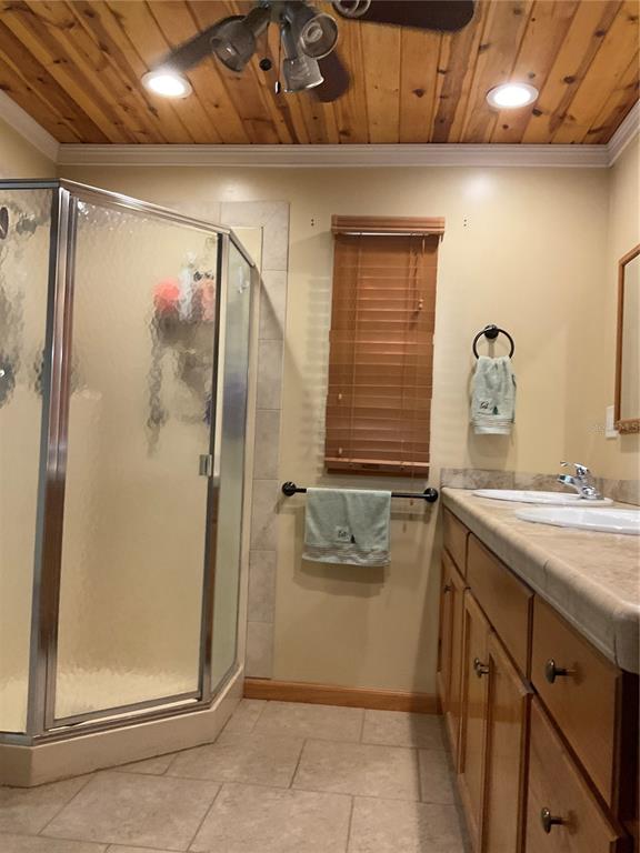 1558 Chobee Street Okeechobee, FL 34974 - Photo 56 of 63 a bathroom with a granite countertop sink a mirror and a shower