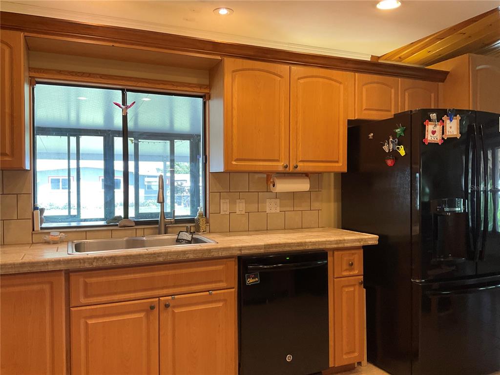 1558 Chobee Street Okeechobee, FL 34974 - Photo 8 of 63 a kitchen with a sink and a refrigerator