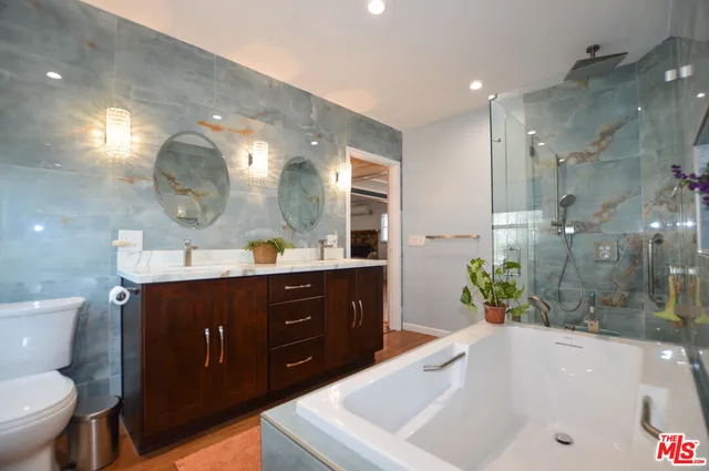 a bathroom with a tub sink and mirror