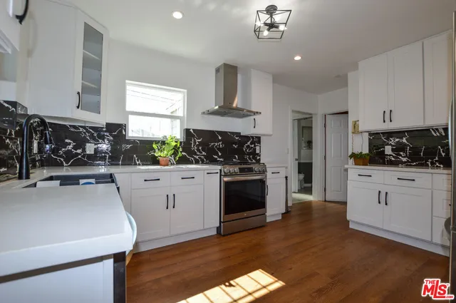 a kitchen with a white stove top oven and white cabinets