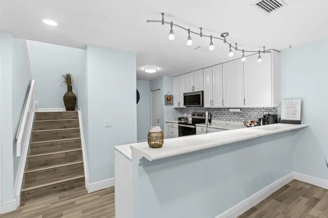 a kitchen with cabinets a sink and appliances
