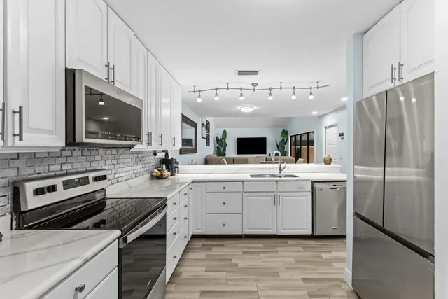 a kitchen with stainless steel appliances a stove microwave and a refrigerator