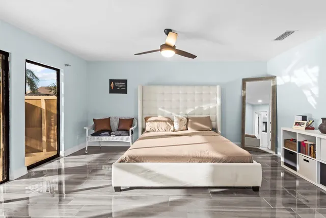 a spacious bedroom with a large bed and a chandelier