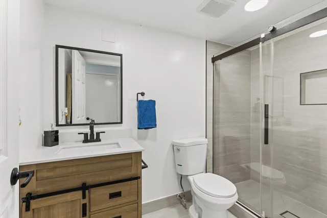 a bathroom with a sink toilet vanity and shower