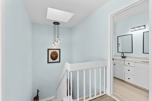 a bathroom with a sink a light fixture and a mirror