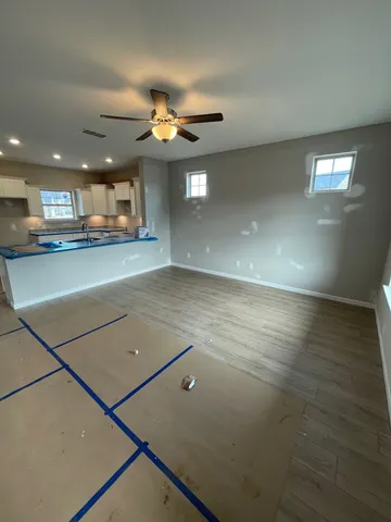 a large kitchen with kitchen island a sink wooden floor and glass doors