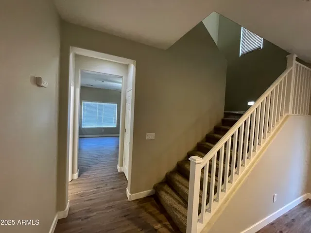 a view of a hallway with wooden floor and staircase