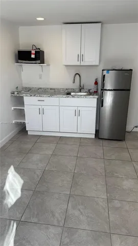 a kitchen with a sink a refrigerator and cabinets