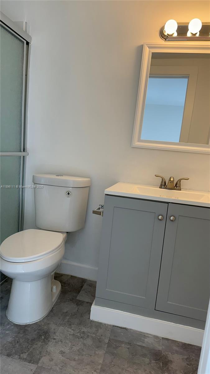12764 Southwest 46th Lane, Unit 12764 Miami, FL 33175 - Photo 7 of 13 a bathroom with a toilet sink and mirror