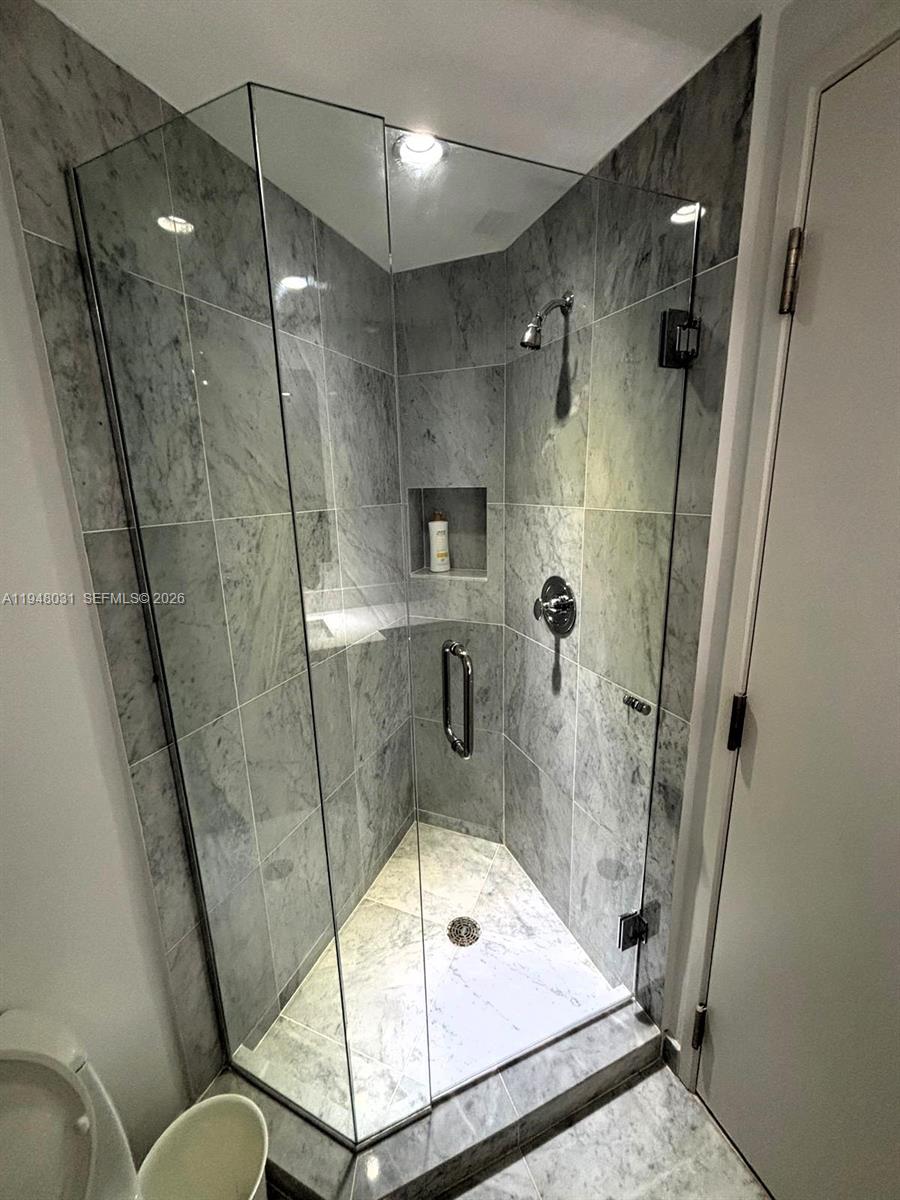 9401 Collins Avenue, Unit 401 Surfside, FL 33154 - Photo 11 of 28 a bathroom with a tub and shower