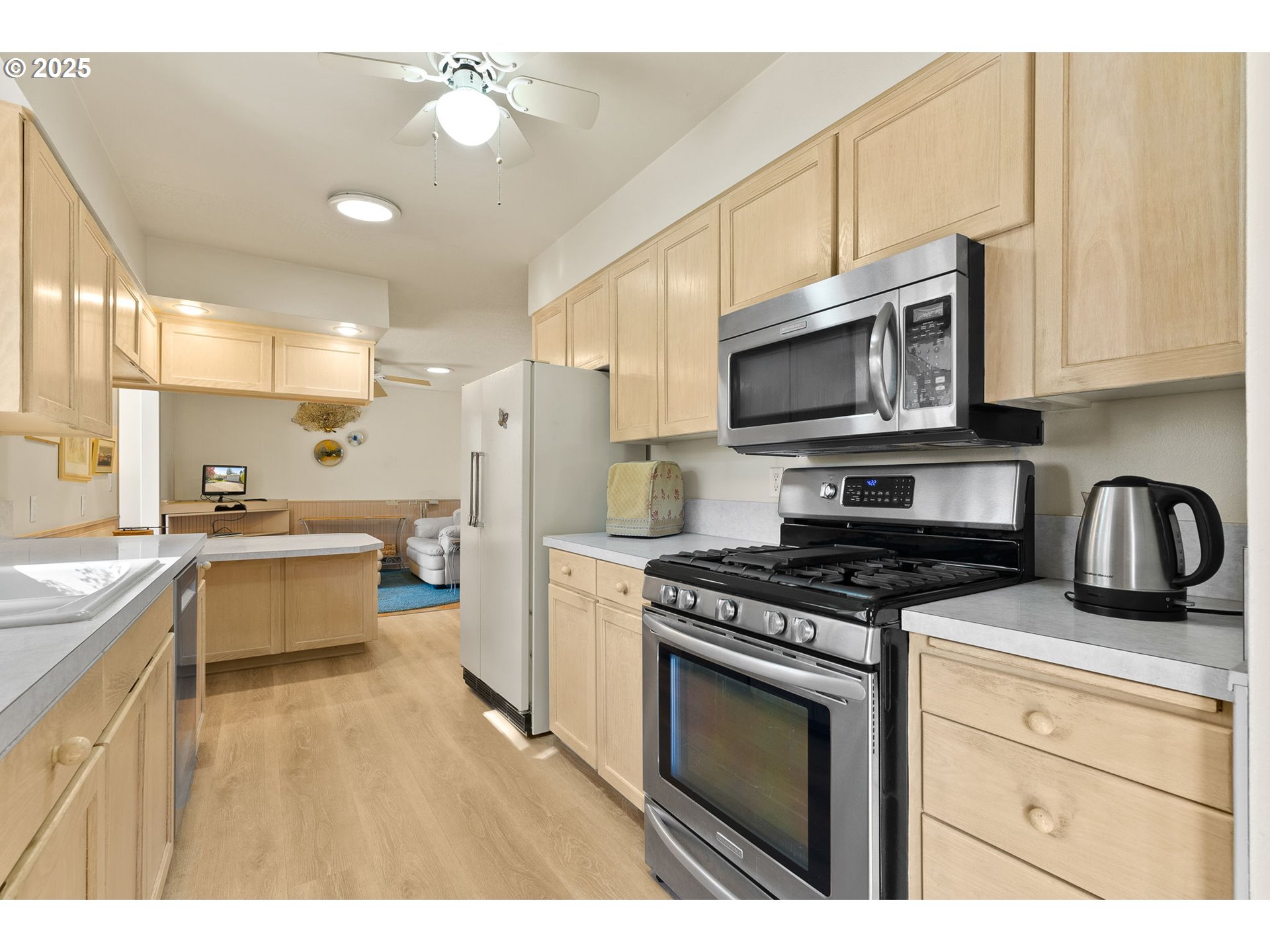 1055 Southeast 214th Avenue Gresham, OR 97030 - Photo 19 of 38 a kitchen with stainless steel appliances granite countertop a stove a sink dishwasher and a microwave oven with white cabinets