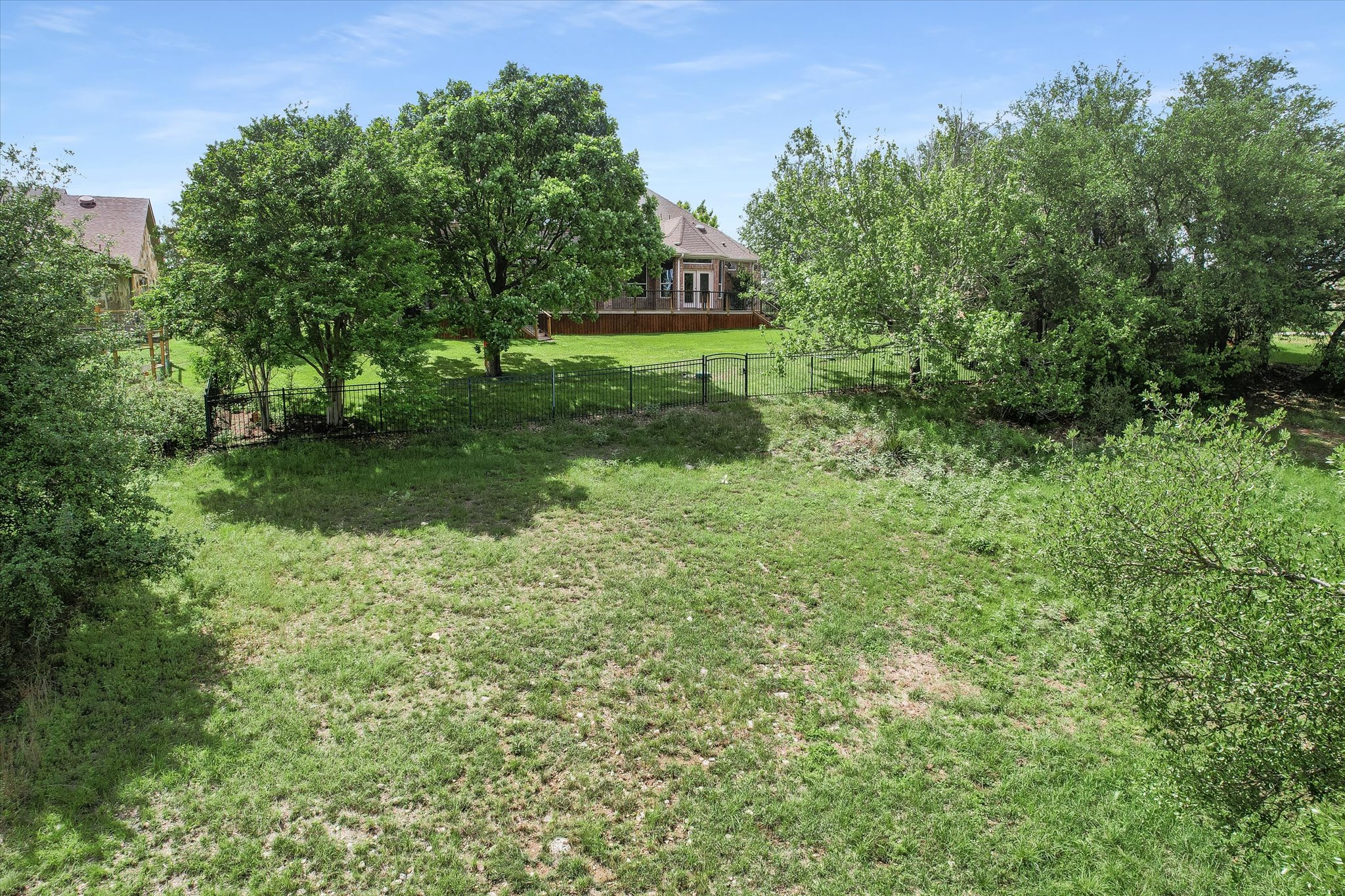 1400 Tom Sawyer Road Austin, TX 78737 - Photo 40 of 40 From behind the back fence, grassy lot with surrounding mature trees