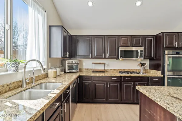 a kitchen with kitchen island granite countertop a sink stove and refrigerator